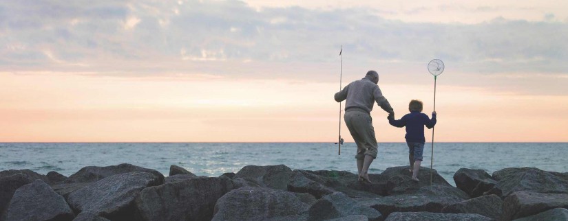 Man and boy fishing by the sea